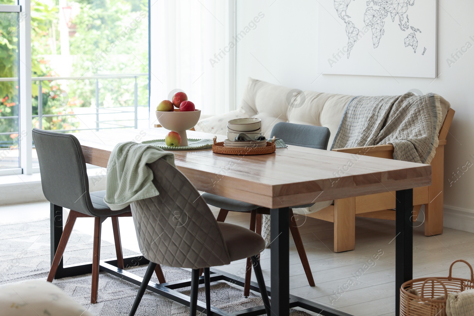 Wooden table, chairs, sofa and decor in dining room. Interior design Photo of Wooden table, chairs, sofa and decor in dining room. Interior design