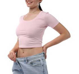 Photo of Woman wearing old jeans after weight loss on white background, closeup