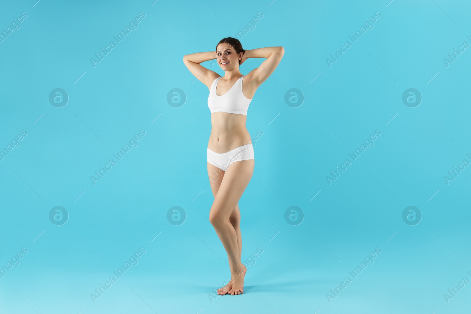 Beautiful woman in underwear on light blue background Photo of Beautiful woman in underwear on light blue background