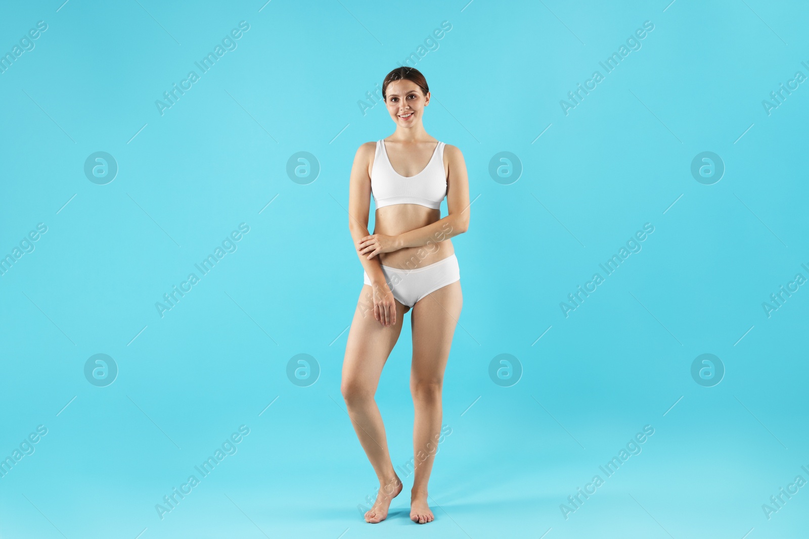 Photo of Beautiful woman in underwear on light blue background