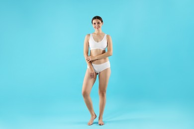 Photo of Beautiful woman in underwear on light blue background