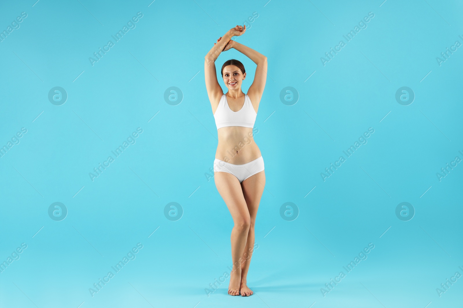 Beautiful woman in underwear on light blue background Photo of Beautiful woman in underwear on light blue background