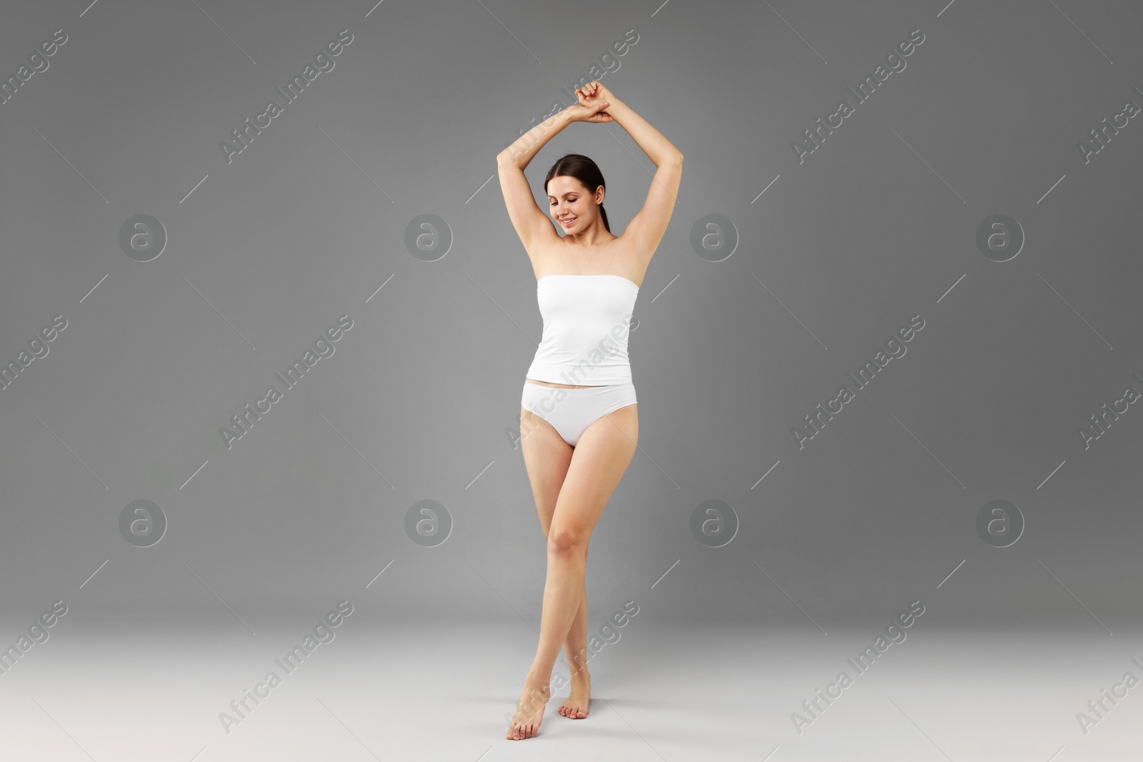 Beautiful woman in underwear on grey background Photo of Beautiful woman in underwear on grey background