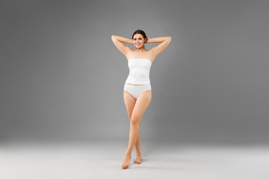 Photo of Beautiful woman in underwear on grey background