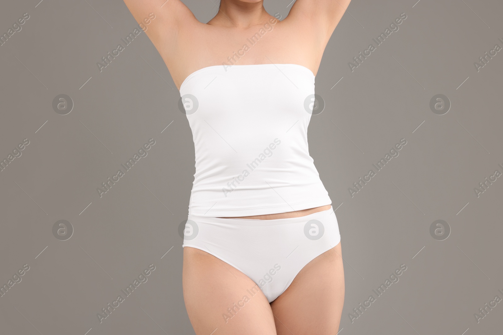 Woman in underwear on grey background, closeup Photo of Woman in underwear on grey background, closeup