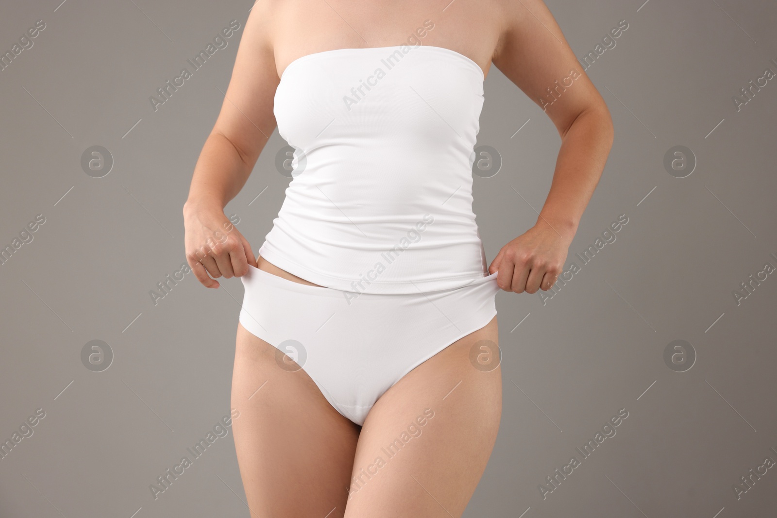 Photo of Woman in underwear on grey background, closeup