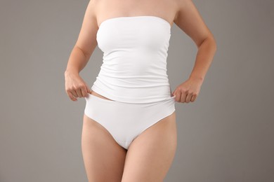 Photo of Woman in underwear on grey background, closeup