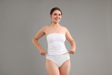 Photo of Beautiful woman in underwear on grey background