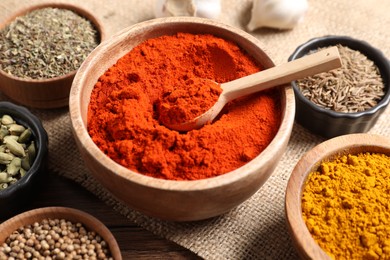 Photo of Different aromatic spices on wooden table, closeup