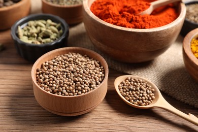 Photo of Different aromatic spices on wooden table, closeup