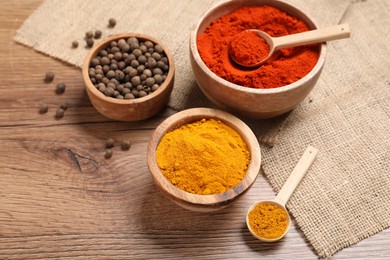 Photo of Different aromatic spices on wooden table, closeup