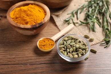 Photo of Different aromatic spices on wooden table, closeup