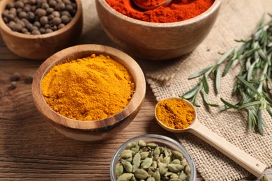 Photo of Different aromatic spices on wooden table, closeup