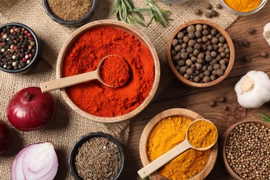 Photo of Different aromatic spices on wooden table, flat lay