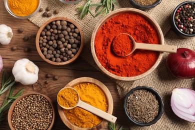 Photo of Different aromatic spices on wooden table, flat lay