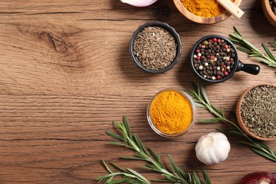Photo of Different aromatic spices on wooden table, flat lay. Space for text