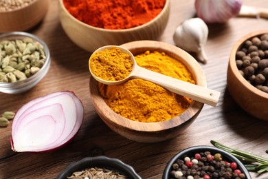 Photo of Different aromatic spices on wooden table, closeup