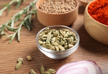 Photo of Different aromatic spices on wooden table, closeup