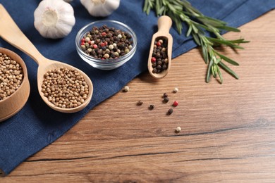 Photo of Different aromatic spices on wooden table. Space for text