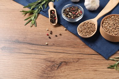 Photo of Different aromatic spices on wooden table. Space for text