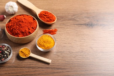 Photo of Different aromatic spices on wooden table. Space for text