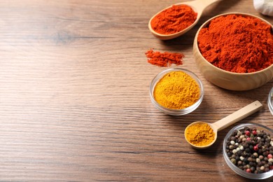 Photo of Different aromatic spices on wooden table. Space for text