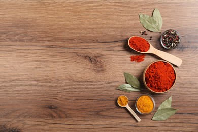 Photo of Different aromatic spices on wooden table, flat lay. Space for text