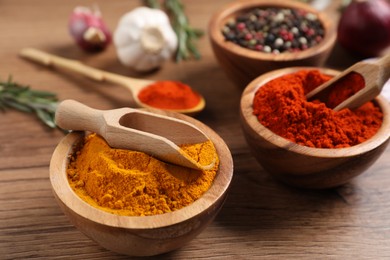 Photo of Different aromatic spices on wooden table, closeup