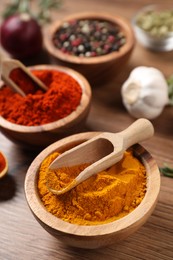 Photo of Different aromatic spices on wooden table, closeup