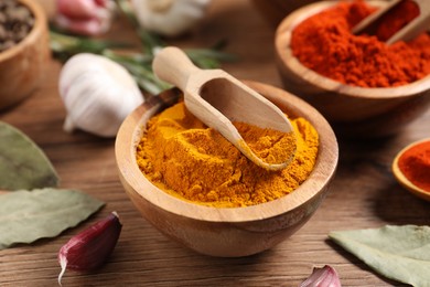 Photo of Different aromatic spices on wooden table, closeup