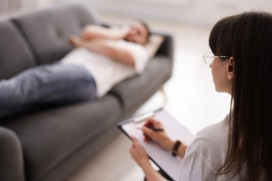 Photo of Professional psychologist working with patient in office, selective focus