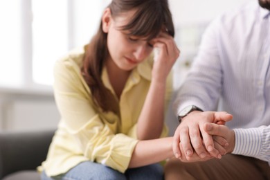 Photo of Psychologist supporting patient during therapy session in office, selective focus