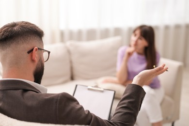 Photo of Professional psychologist working with patient in office, selective focus