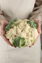 Photo of Woman with whole raw cauliflower head, closeup