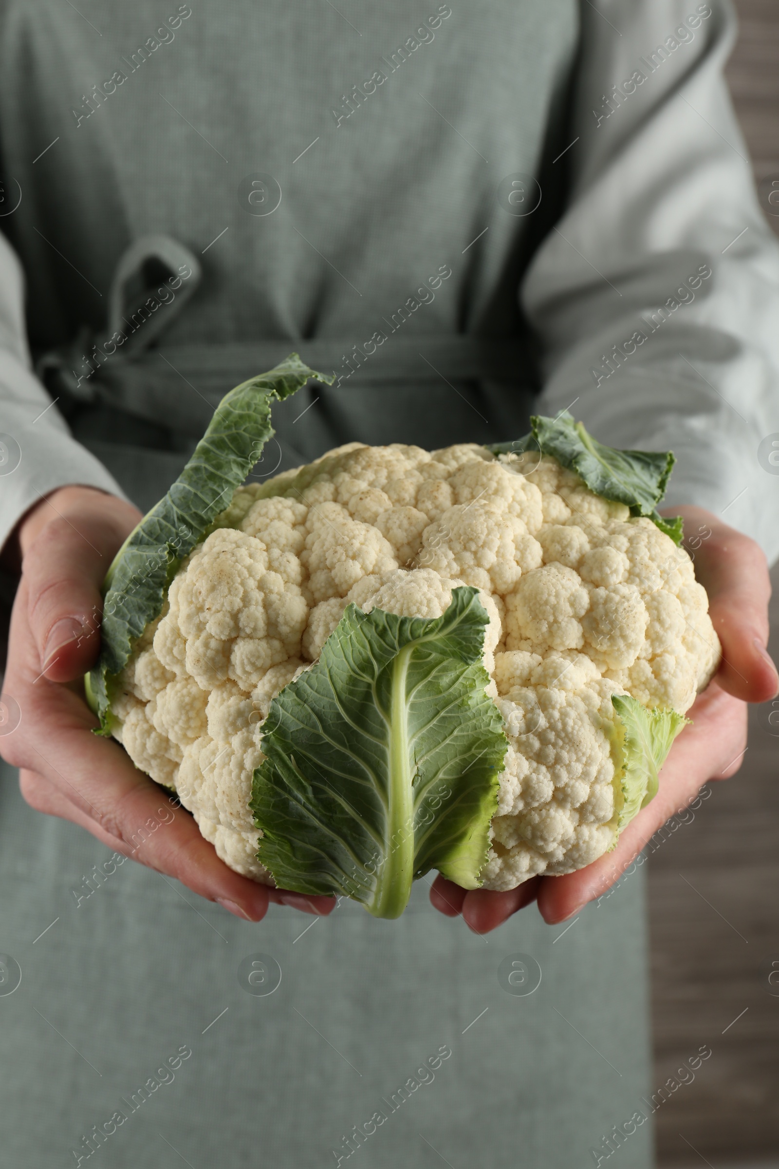 Woman with whole cauliflower on wooden background, closeup Photo of Woman with whole cauliflower on wooden background, closeup