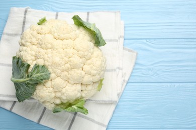 Photo of Whole cauliflower on light blue wooden table, top view. Space for text