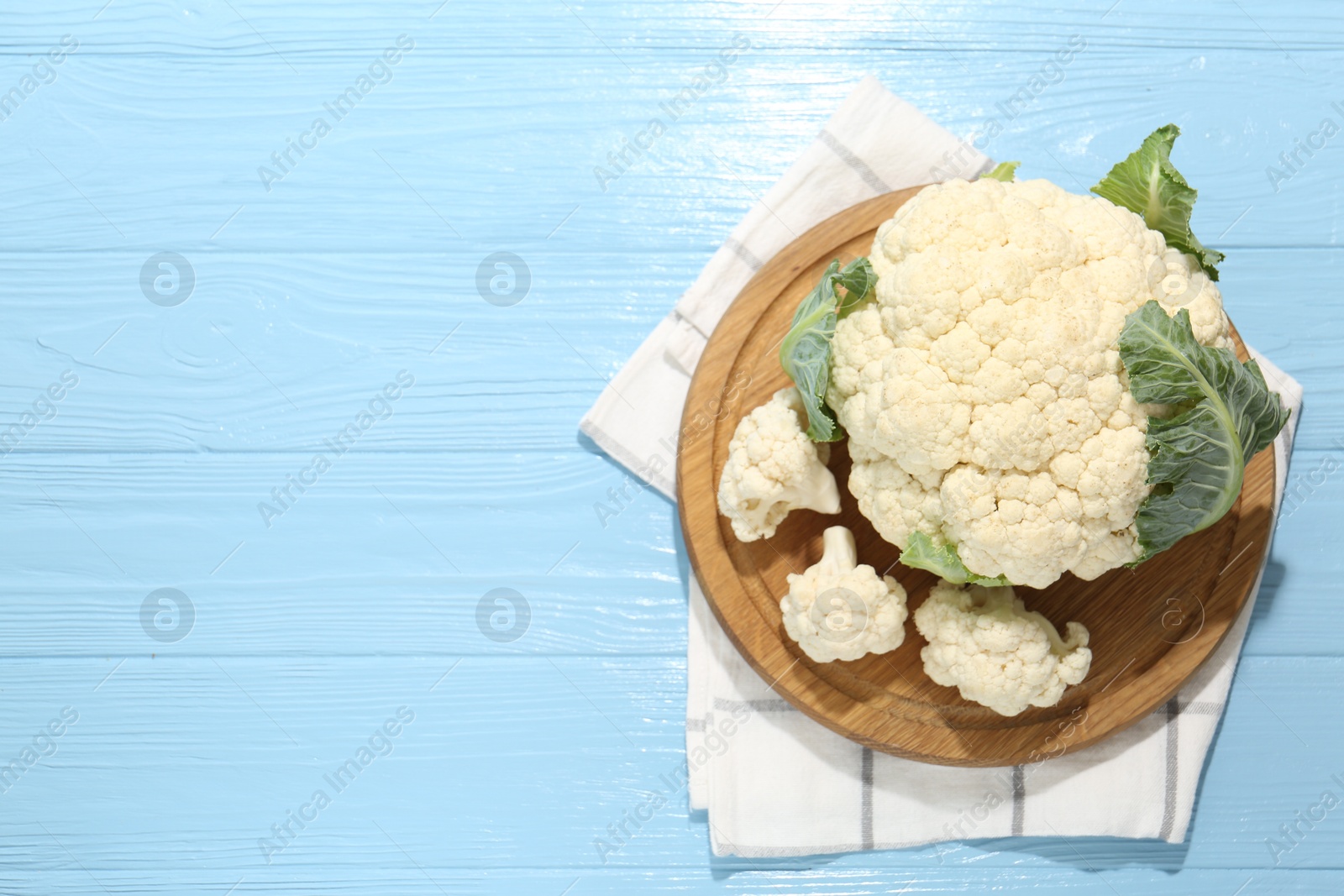 Raw cauliflower on light blue wooden table, top view. Space for text Photo of Raw cauliflower on light blue wooden table, top view. Space for text