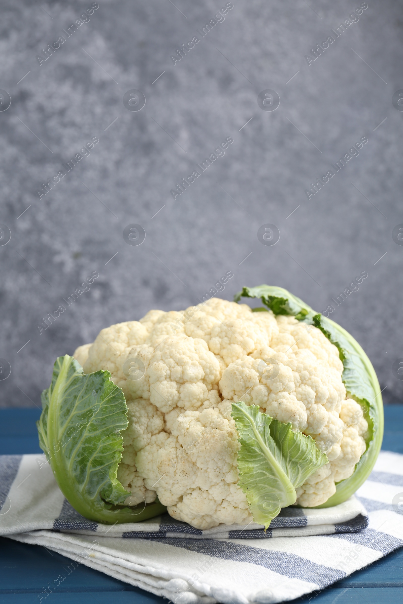 Whole raw cauliflower on blue wooden table Photo of Whole raw cauliflower on blue wooden table