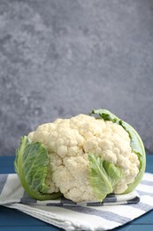 Photo of Whole raw cauliflower on blue wooden table