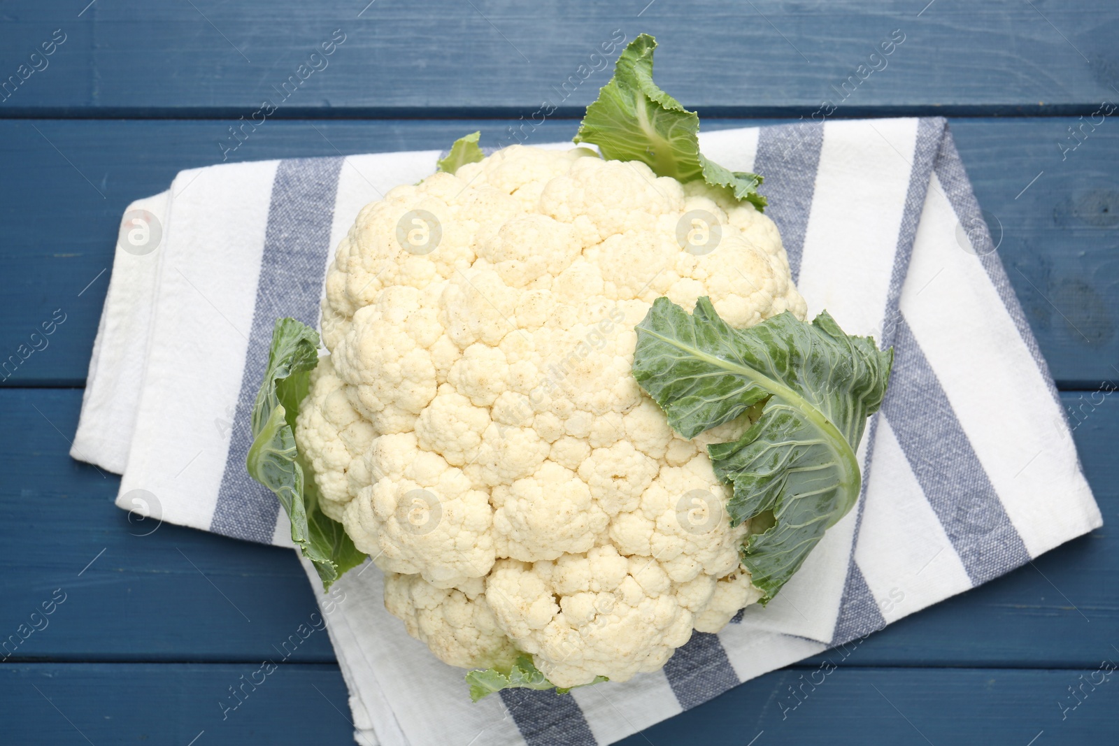 Whole cauliflower on blue wooden table, top view Photo of Whole cauliflower on blue wooden table, top view