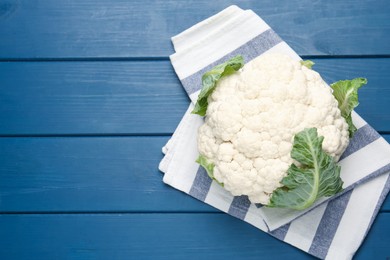 Photo of Whole cauliflower on blue wooden table, top view. Space for text