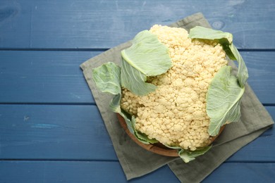 Photo of Whole cauliflower on blue wooden table, top view. Space for text