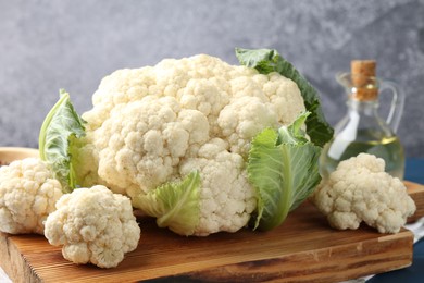 Photo of Raw cauliflower and oil on table, closeup