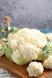 Photo of Raw cauliflower and oil on table, closeup