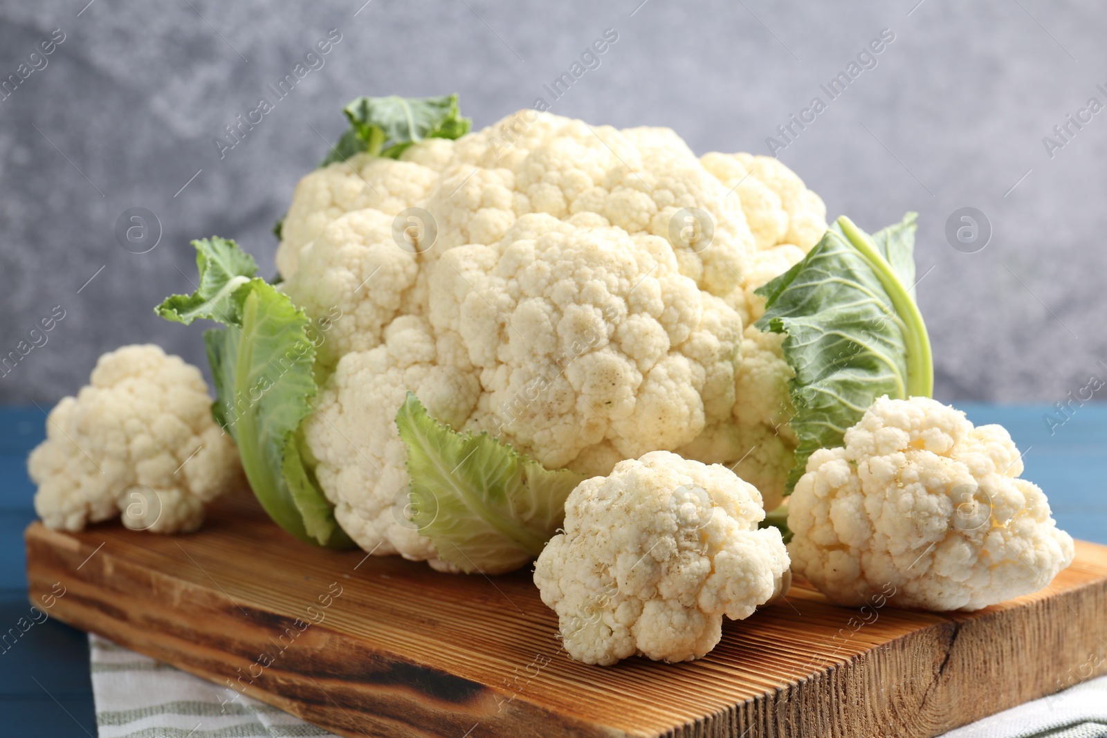 Raw cauliflower on blue wooden table, closeup Photo of Raw cauliflower on blue wooden table, closeup
