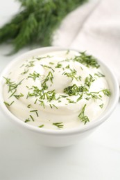 Photo of Delicious yogurt in bowl and dill on white table, closeup