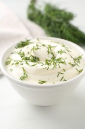 Photo of Delicious yogurt in bowl and dill on white table, closeup