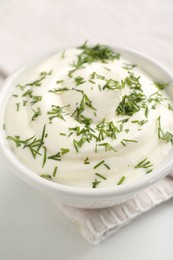 Photo of Delicious yogurt in bowl and dill on white table, closeup