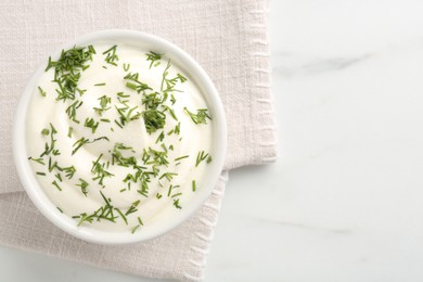 Photo of Delicious yogurt in bowl and dill on white marble table, top view. Space for text