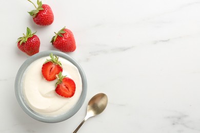 Photo of Delicious yogurt in bowl, strawberries and spoon on white marble table, flat lay. Space for text